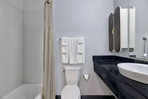 Ein modernes Badezimmer mit Badewanne, Toilette und Waschbecken.