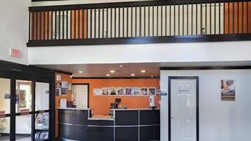 A reception area with a counter, a door labeled 'EMPLOYEES ONLY,' and a bulletin board with various notices.