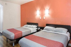 A hotel room with two beds, each with a white and red blanket, and a nightstand with a phone. - 2 full beds | non-smoking, micfridge (Fort Worth)