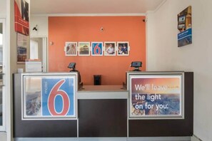 A reception desk with a number 6 sign, a motivational quote, and a series of framed pictures on the wall behind. - 2 full beds | non-smoking, micfridge (Fort Worth)