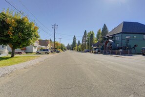 A residential street with houses, parked cars, and a large water wheel structure. - McCloud Retreat Near Mt Shasta & Waterfalls! (McCloud)