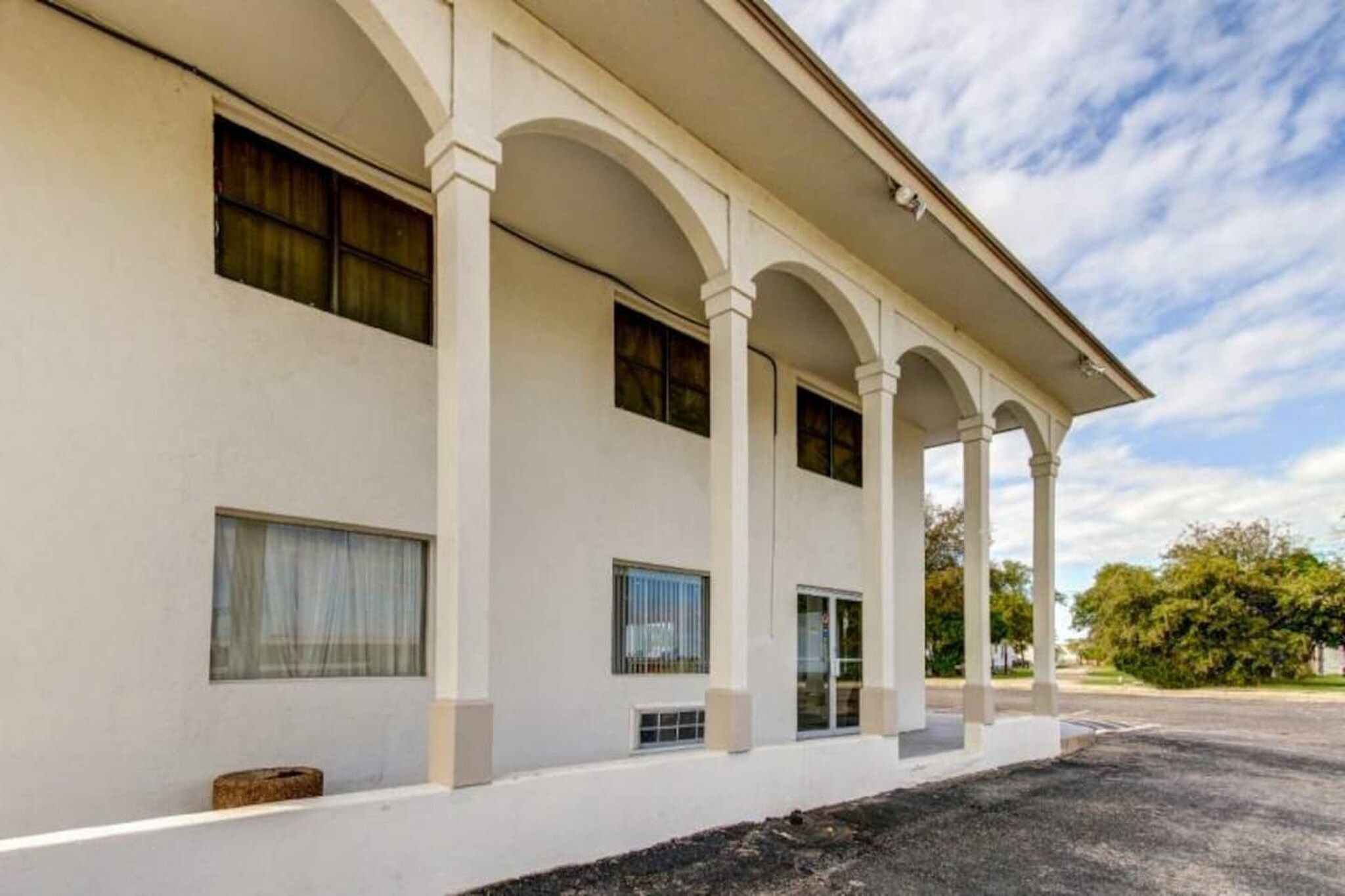 A building with a series of columns supporting a covered porch area.