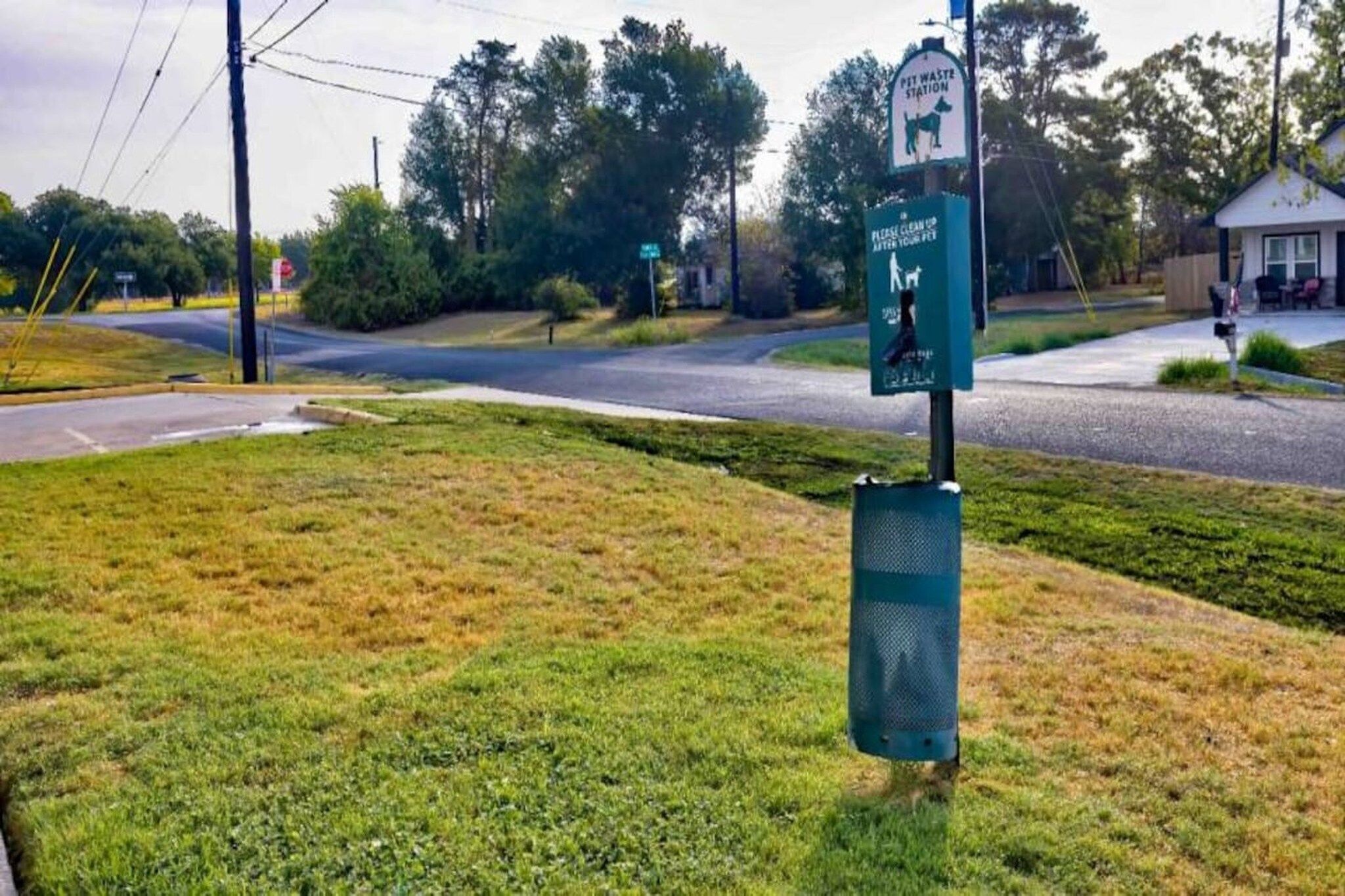 Un cartel al borde de la carretera que indica una estación de descarga de lodos y un contenedor de basura.