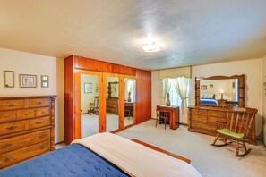 A bedroom with a bed, dresser, mirror, and a door leading to another room. - 1 Mi to Notre Dame & Dtwn: Charming Home w/ Yard (South Bend)