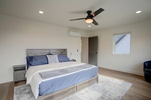 A bedroom with a bed, nightstands, a ceiling fan, an air conditioning unit, a window, and a door. - 4 Mi to Slopes! Eden Home w/ Private Hot Tub (Eden)