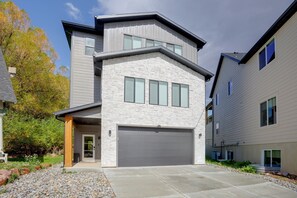 A modern two-story house with a garage, stone facade, and a well-maintained front yard. - 4 Mi to Slopes! Eden Home w/ Private Hot Tub (Eden)