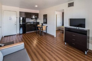 A compact living space with a kitchenette, a dining area, a sofa, and a TV. - 2 Full Beds |Suite,Nsmk,Kitchen (Arlington)