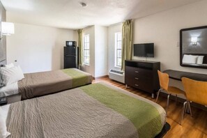 A hotel room with two beds, a desk, a chair, a TV, and a wardrobe. - 2 Full Beds |Suite,Nsmk,Kitchen (Arlington)