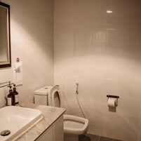 A bathroom with a sink, toilet, and a mirror.