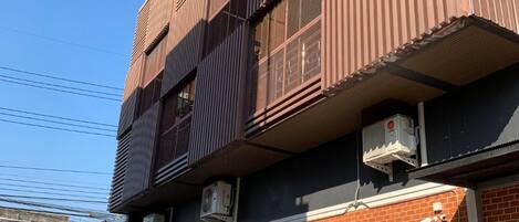 A multi-story building with a modern design, featuring large windows and air conditioning units.