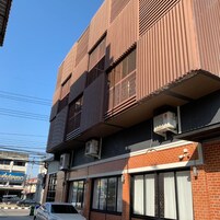 A multi-story building with a modern design, featuring large windows and air conditioning units.