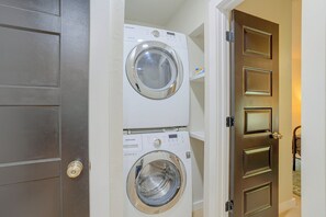 A laundry room with two stacked front-loading washing machines. - Guthrie Home in the Heart of Historic Downtown! (Guthrie)