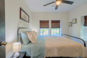 A bedroom with a bed, a ceiling fan, a window with blinds, and a wall-mounted picture. - Guthrie Home in the Heart of Historic Downtown! (Guthrie)