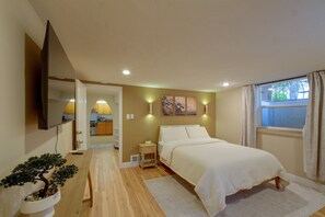 Ein Schlafzimmer mit einem Bett, einem Nachttisch, einer Lampe und einer Topfpflanze.