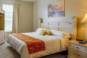 A hotel room with a bed, a nightstand, a lamp, and a painting on the wall. - Resort Perks! Family Condo 4 Mi to Disney World! (Kissimmee)