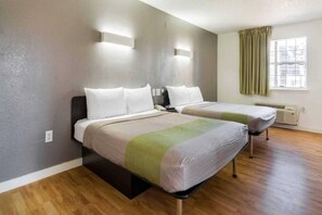 A hotel room with two beds, a window with curtains, and a built-in air conditioning unit. - 2 Queen Beds | Non-Smoking, Kitchen (Plano)