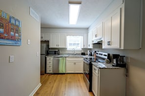 A compact kitchen with white cabinets, a stainless steel refrigerator, a microwave, and a coffee maker. - 6 Mi to the Masters: North Augusta Condo (North Augusta)