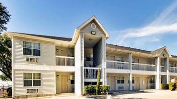 A multi-story motel with a central entrance, balconies, and a parking lot.