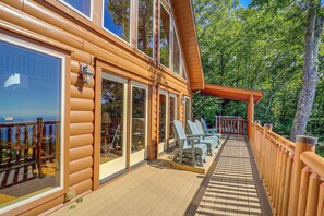 A wooden deck with outdoor seating and a view of the surrounding trees. - Hot Tub, Fire Pit, Views & More: Blowing Rock Gem (Blowing Rock)