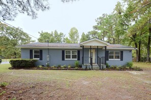 A single-story house with a front porch, a small garden, and a clear sky. - Hidden Orangeburg Gem! Spacious modern Deco Ranch (Orangeburg)
