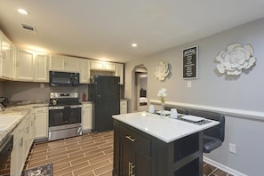 A modern kitchen with white cabinets, stainless steel appliances, and a marble countertop. - Hidden Orangeburg Gem! Spacious modern Deco Ranch (Orangeburg)
