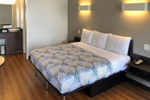 Ett hotellrum med en säng, sängbord, ett skrivbord och en spegel.
