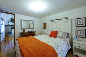 A bedroom with a bed, dresser, nightstand, and a mirror. - Fishing Cabin on Lake Bob Sandlin (Leesburg)