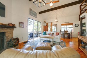 A spacious living room with a fireplace, a dining area, and a large window providing natural light. - Fishing Cabin on Lake Bob Sandlin (Leesburg)
