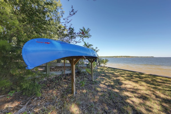 A blue kayak secured under a wooden structure by a lakeside. - Fishing Cabin on Lake Bob Sandlin (Leesburg)