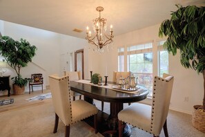 A dining area with a dark wooden table, beige upholstered chairs, a chandelier, and potted plants. - Private Pool! Home 4 Mi to Old Town Spring (Spring)