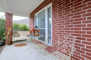 A covered patio with a brick wall, a glass door, and a seating area with a table and chairs. - Private Pool! Home 4 Mi to Old Town Spring (Spring)