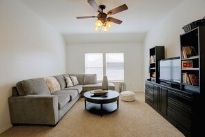A living room with a sectional sofa, a coffee table, a bookshelf, and a ceiling fan. - Private Pool! Home 4 Mi to Old Town Spring (Spring)