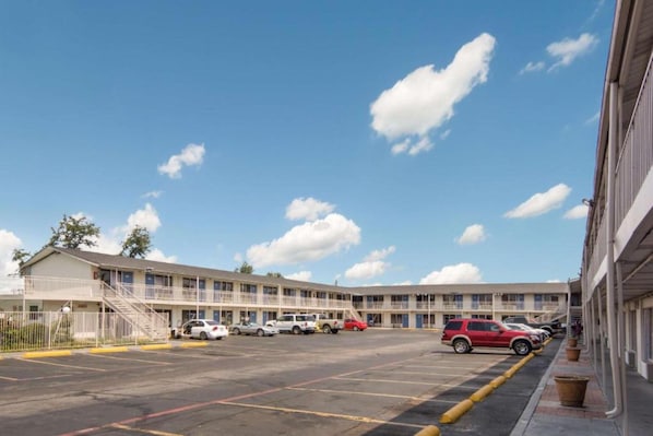A motel with a parking lot and multiple vehicles parked. - 1 King Bed | Smoking, Micfridge (Fort Worth)