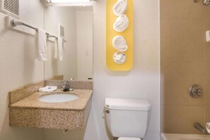 A bathroom with a sink, toilet, and a towel rack with towels. - 1 King Bed | Smoking, Micfridge (Fort Worth)