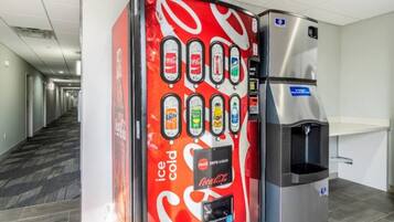 Ein Getränkeautomat mit Coca-Cola-Logo und Wasserspender in einem Flur.