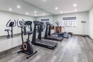 Una palestra con tapis roulant, ellittiche e una cyclette.