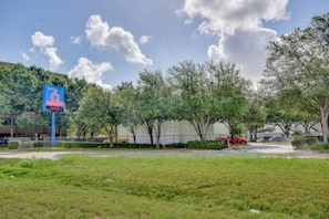 A grassy area with a blue sign indicating a studio rental. - 1 Queen Bed | ADA/Tub, Nsmk (Houston)