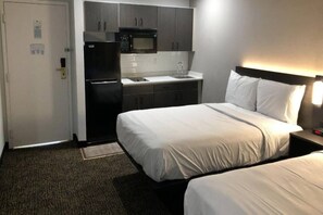 A hotel room with a bed, a nightstand, a lamp, a microwave, and a refrigerator. - 2 Full Beds | Non-Smoking, Kitchen (Killeen TX)