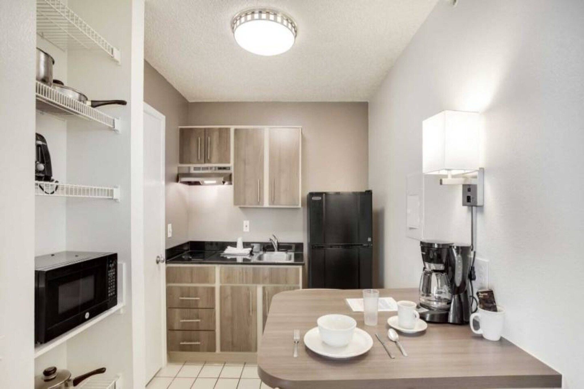 A compact kitchen with a microwave, refrigerator, and coffee maker.