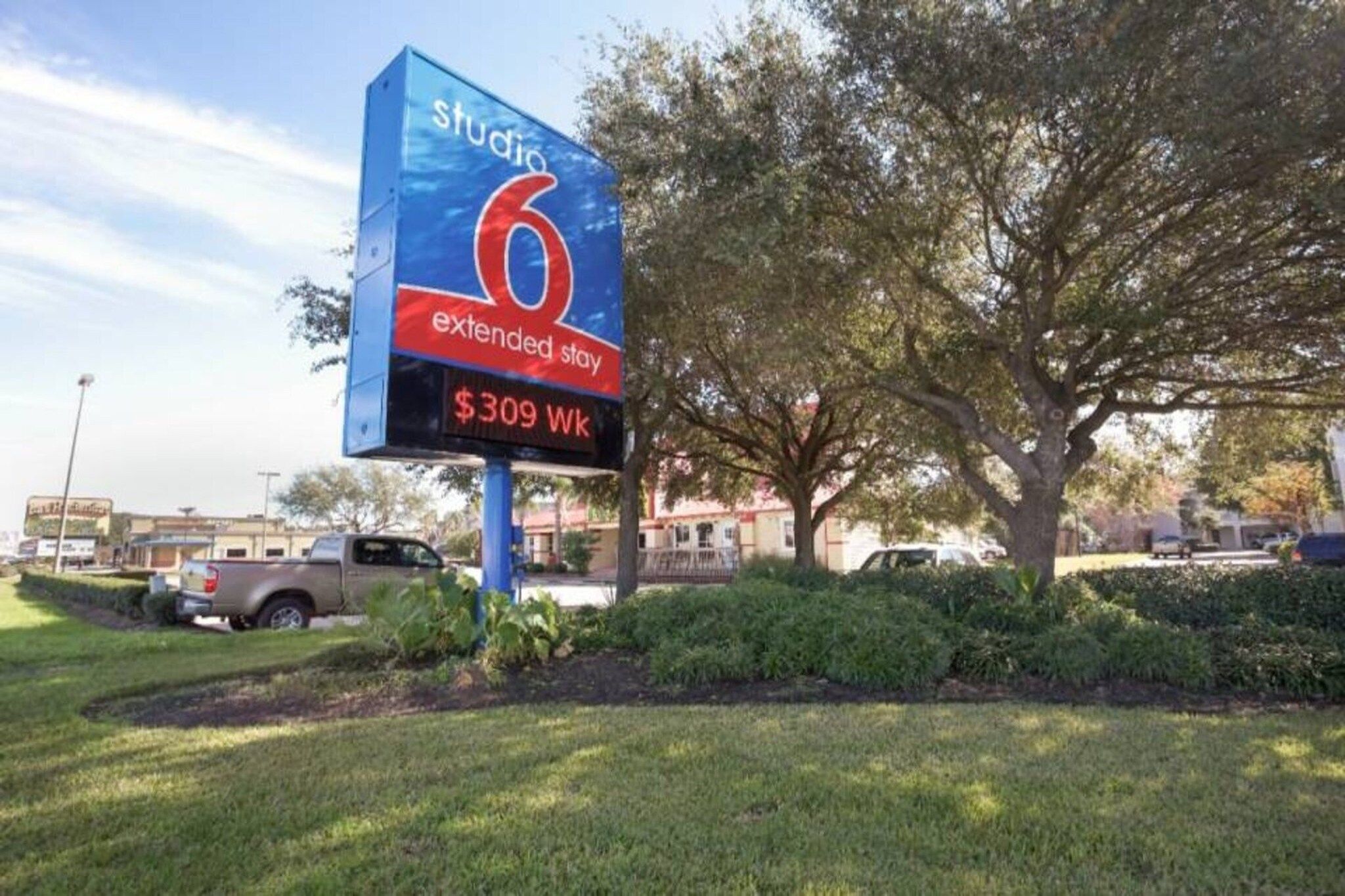A hotel sign with the name 'Studio 6' and 'extended stay' indicating a 7-night stay for $309 per week.