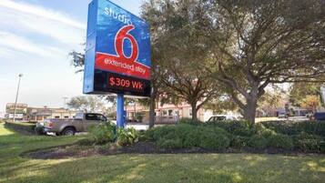 A hotel sign with the name 'Studio 6' and 'extended stay' indicating a 7-night stay for $309 per week.