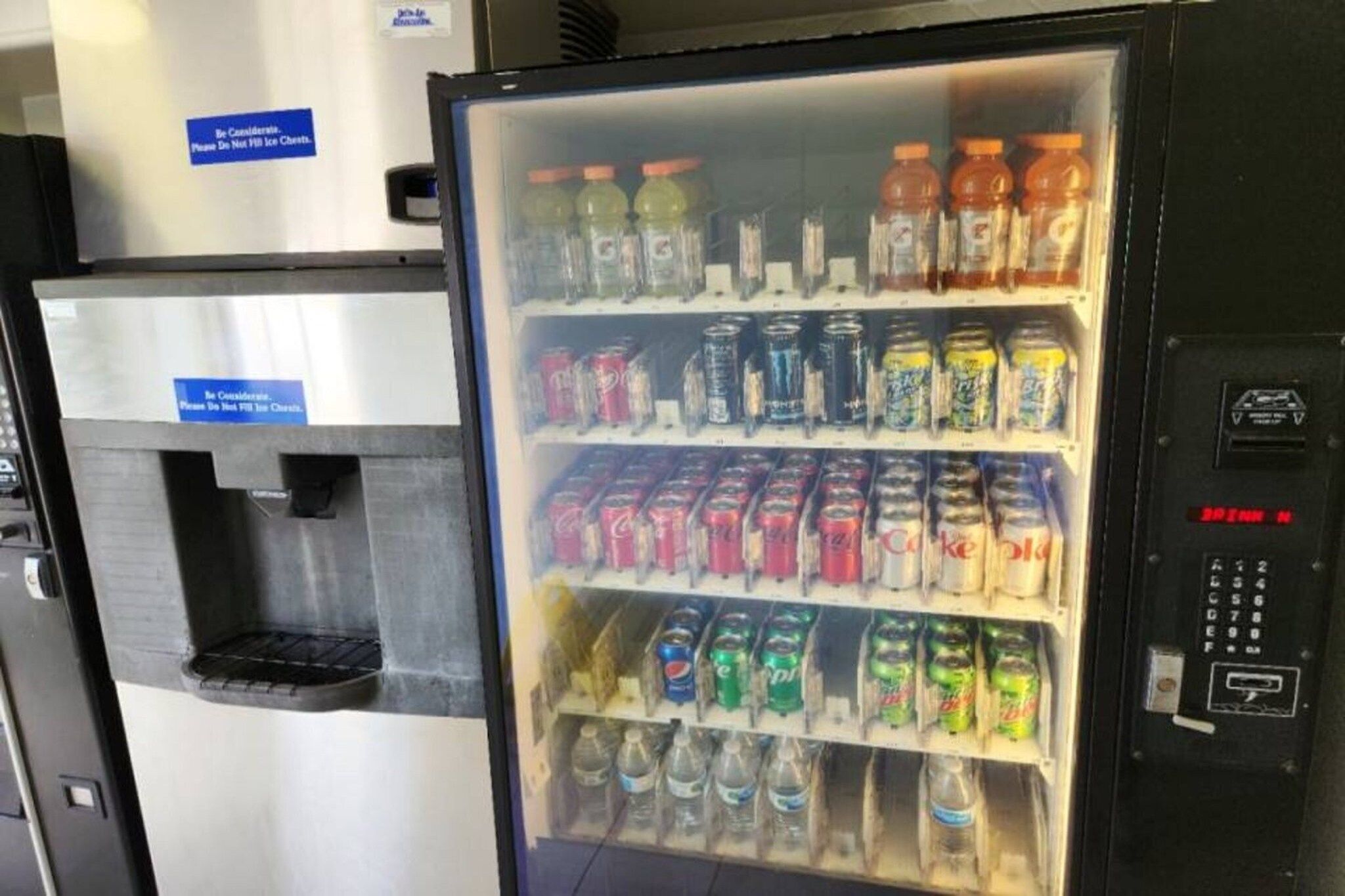 A beverage vending machine with multiple drink options including sodas and juices.