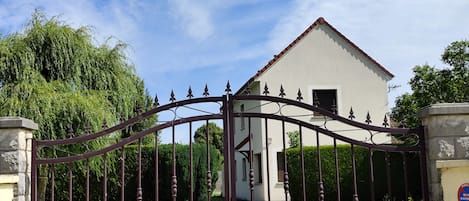 A gated entrance with a white building in the background.