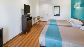 A hotel room with a bed, a desk, a chair, a television, and a wardrobe.