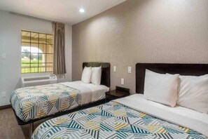 Une chambre d’hôtel avec deux lits, une fenêtre avec des rideaux, un appareil de climatisation et une vue sur l’extérieur.