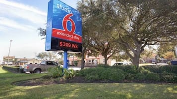 Un letrero de hotel con el nombre 'Studio 6' e información sobre estadías prolongadas, indicando una opción de estadía de 7 noches.