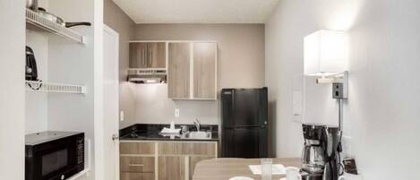 A compact kitchen with a microwave, refrigerator, and coffee maker.