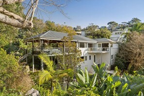 A residential property with a two-story house, a covered outdoor area, and lush vegetation. - EDBAY - Edwards Beach Retreat | Steps To Balmoral (Mosman)