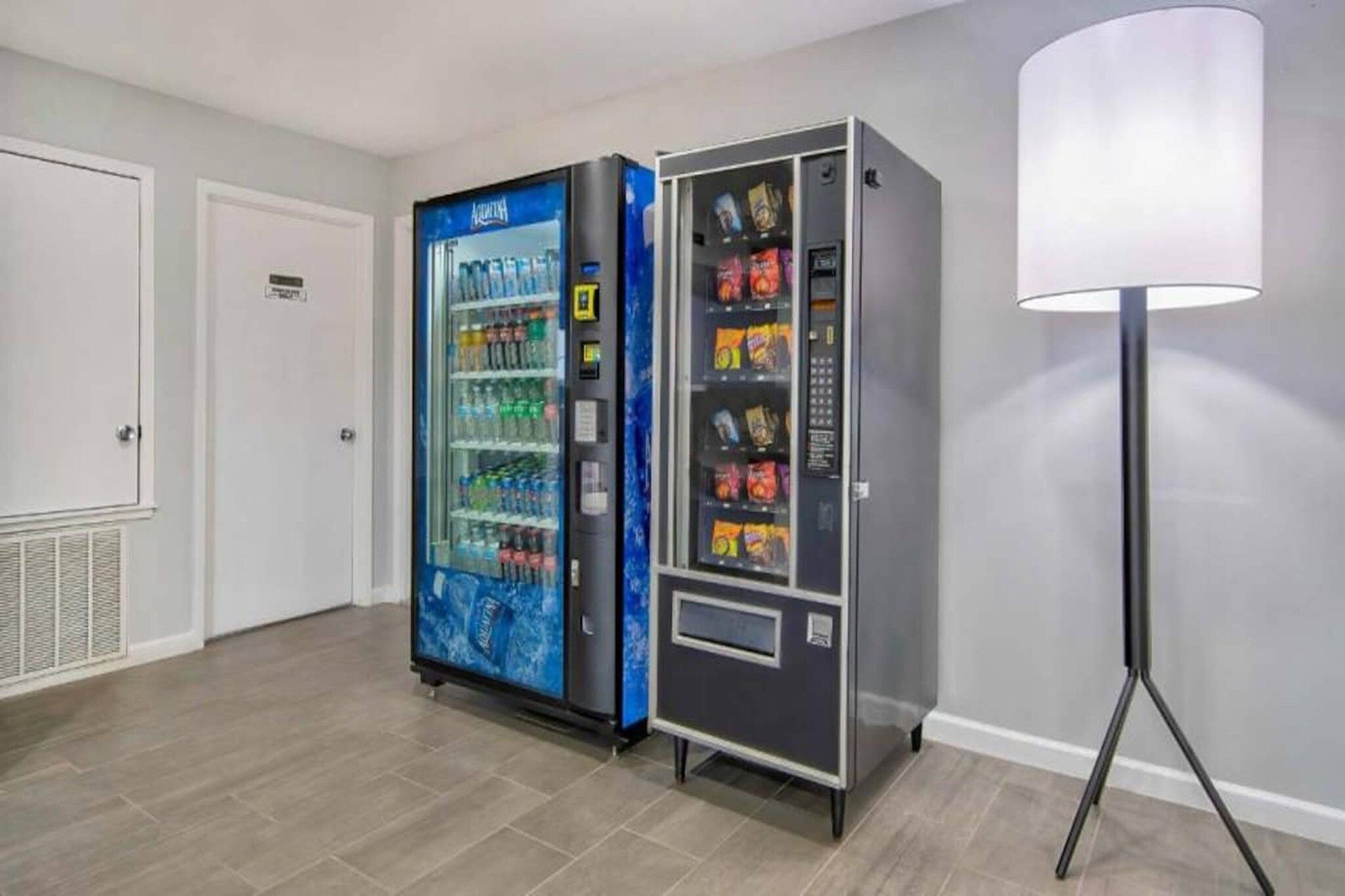 Un espace équipé d’un distributeur automatique de boissons et d’un autre distributeur automatique de collations.
