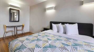 Una habitación de hotel con una cama, un escritorio y una silla.